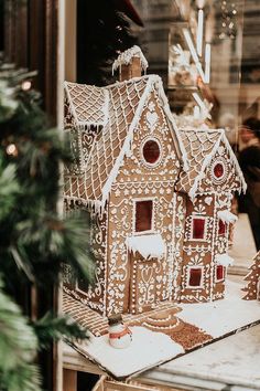 a gingerbread house sitting on top of a table in front of a store window