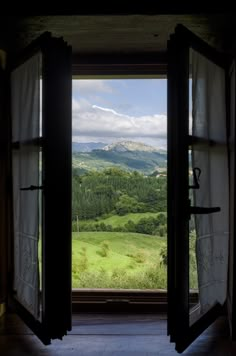 an open door leading to a lush green valley