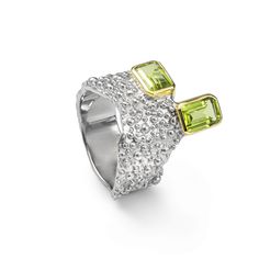 This ring from German Kabirski's Buds and Beans Collection challenges conventional design with its unique setting of two octagon-cut Peridot gemstones. One stone is set vertically, the other horizontally, embodying a design perfect for those who appreciate seeing things from multiple perspectives and find harmony in contrasts. The dual plating of White Rhodium and 18K Gold enhances the design's complexity, while the band's organic-like texture—a signature of Kabirski's work—adds an earthy, tacti Modern Octagon Jewelry With Accent Stones, Luxury Multi-stone Peridot Jewelry, Luxury Peridot Multi-stone Jewelry, Modern Multi-stone Emerald Cut Jewelry, Modern Peridot Jewelry For Formal Occasions, Emerald Cut Peridot Jewelry For Formal Occasions, Emerald Cut Peridot Jewelry For Formal Events, Formal Emerald Cut Peridot Jewelry, Formal Multi-stone Peridot Jewelry