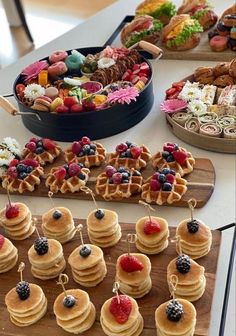 a table topped with lots of waffles covered in berries and other toppings