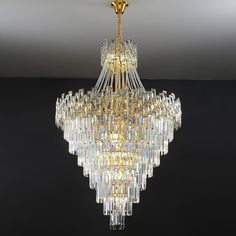 a large chandelier hanging from the ceiling in a room with black walls and flooring