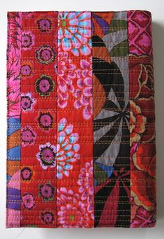 an orange and pink patchwork wallet with flowers on it