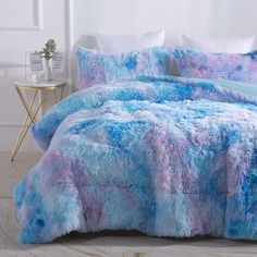 a blue and pink comforter set on a bed