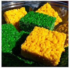 four pieces of rice krispy treats on a plate with green and yellow frosting