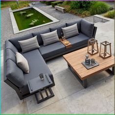 a couch and coffee table sitting on top of a cement floor next to a pond