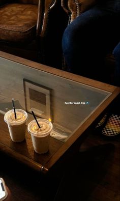 two cups of coffee sitting on top of a table