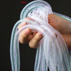 a hand holding a white string with green lights on it