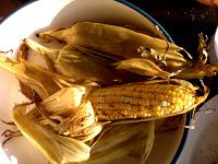 corn on the cob is sitting in a bowl next to some other food items