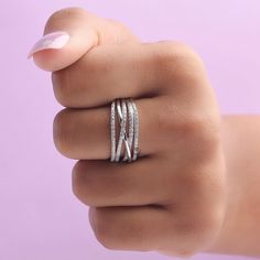 a woman's hand with two silver rings on top of her finger and one ring in the middle