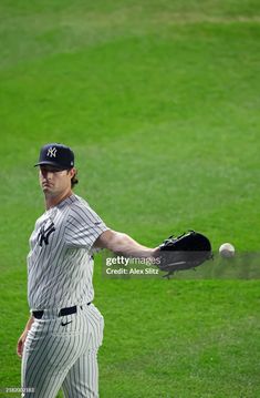 a baseball player throwing a ball on top of a lush green field with his glove in the air