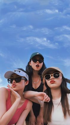 three young women wearing hats and sunglasses posing for the camera with their arms around each other