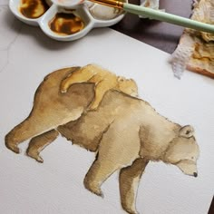 a drawing of a bear on paper next to some paint