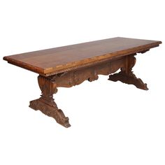 an old wooden table with carvings on the top and legs, against a white background