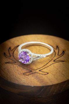 a close up of a ring on top of a wooden box with an engraved design