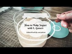 a person is cutting up some food in a glass bowl with a spoon on the table