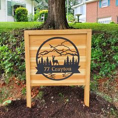 a wooden sign sitting in front of a tree