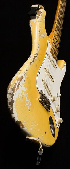 an old yellow and white guitar is on display