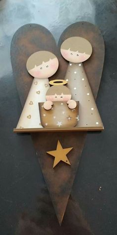 two angels are sitting on top of a heart shaped object with stars around it and one is holding a baby in the other's arms