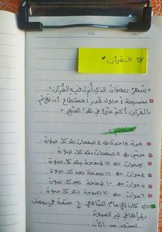 an open notebook with writing on it and sticky notes attached to the pages in arabic