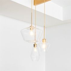 three clear glass pendant lights hanging from a ceiling