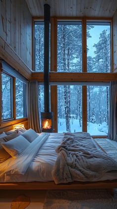 a large bed sitting in front of a window next to a fire place