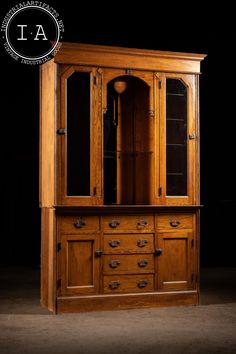 a wooden cabinet with glass doors and drawers on it's sides, against a black background