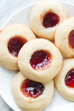 small cookies with jelly filling on a white plate