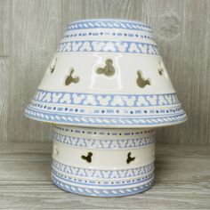 a blue and white vase sitting on top of a wooden table next to a wall