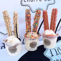 three ice creams with sprinkles and candy sticks