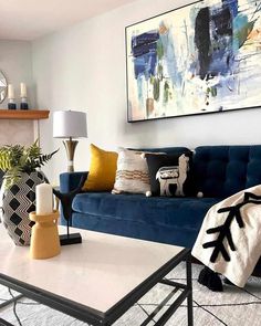 a living room with blue couches and white rugs on the floor in front of a fireplace