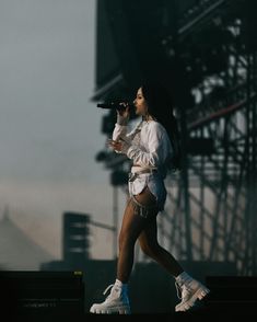 a woman in black and white outfit holding a microphone