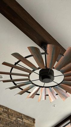 a light fixture hanging from the ceiling in a room with brick walls and wood beams