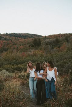 four girls standing together in the middle of a field