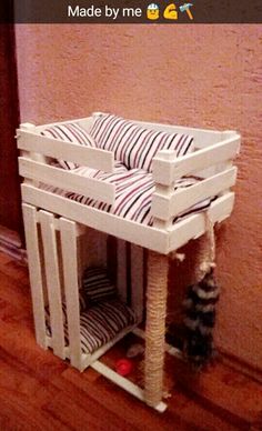 a cat bed made out of wooden crates