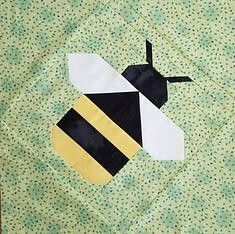 a patchwork quilt with a black and yellow bee on it's back side