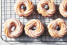 six glazed doughnuts on a cooling rack ready to be baked in the oven