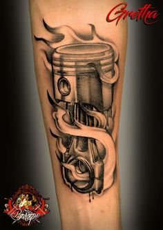 a black and white photo of a tattoo on the leg of a man with a car engine