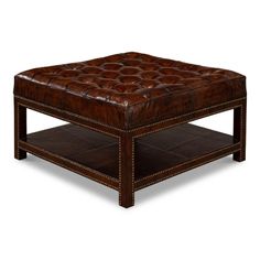 a brown leather ottoman sitting on top of a wooden table