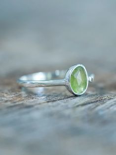 The rose cut peridot (August birthstone) shines alongside a tiny round green sapphire (September birthstone), both held securely in a bezel setting. Pair your peridot ring with peridot earrings to channel a free spirited and joyful vibe. Let this ring be the statement piece that adds a touch of whimsy and elegance to your style. Each piece of our jewelry is handcrafted with love. Peridot Gemstone Stackable Rings For May Birthstone, Stackable Peridot Gemstone Rings For May Birthstone, Green Peridot Birthstone Ring, Dainty Style, Lime Green Peridot Ring For May Birthstone, Lime Green Peridot Birthstone Ring For May, Peridot Gemstone Stackable Rings, Green Sapphire Sterling Silver Ring For May Birthstone, Stackable Peridot Gemstone Rings, Green Sapphire Ring For May Birthstone In Sterling Silver