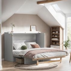 a bed sitting under a window next to a book shelf in a room with white walls