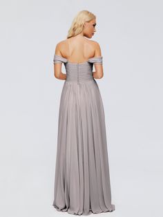 a woman in a long grey dress looking off to the side with her back turned