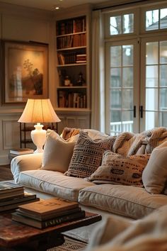 a living room filled with lots of furniture next to a lamp and bookshelf