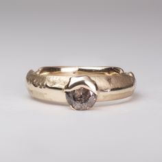 a close up of a gold ring with a diamond in it's center on a white background