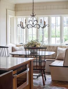 a living room filled with furniture and a chandelier hanging over a dining table