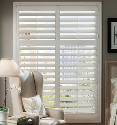 a white chair sitting in front of a window covered in blinds