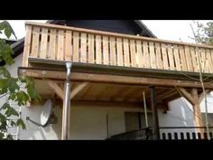 a wooden balcony attached to the side of a house