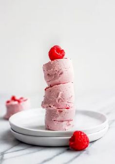 three pieces of cake on a plate with raspberries