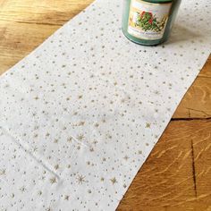 a candle sitting on top of a table next to a white napkin with gold stars