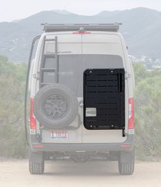 the back end of a white van on a dirt road