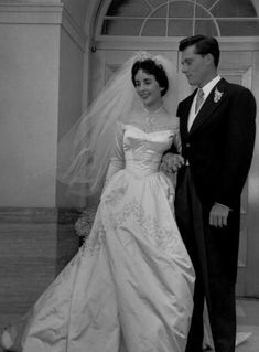 a bride and groom standing in front of a doorway